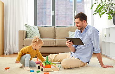 Image showing father with tablet pc and baby daughter at home