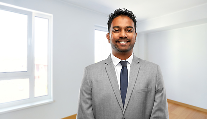 Image showing smiling indian man realtor at new apartment