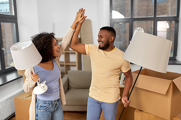 Image showing happy couple packing boxes and moving to new home