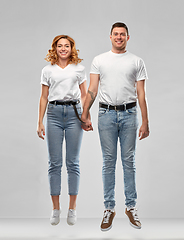 Image showing happy couple in white t-shirts jumping or hanging