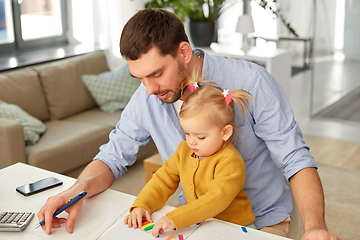 Image showing working father with baby daughter at home office