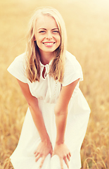 Image showing smiling young woman in white dress on cereal field