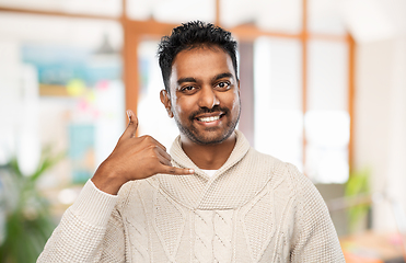 Image showing indian man in sweater making phone call gesture