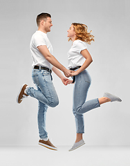 Image showing happy couple in white t-shirts jumping