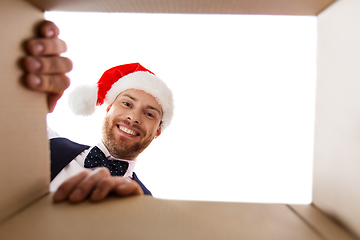 Image showing happy young man looking into open christmas gift