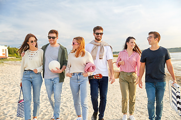 Image showing happy friends walking along summer beach