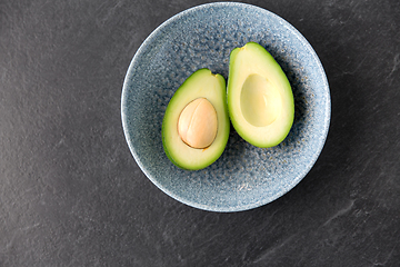 Image showing close up of ripe avocado with bone in ceramic bowl