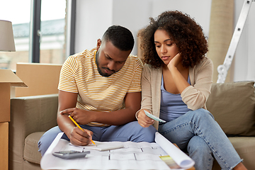 Image showing sad couple with blueprint counting money at home