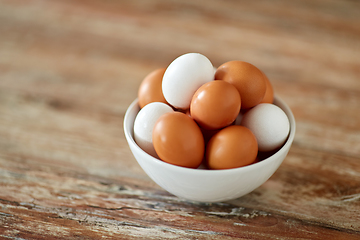 Image showing close up of eggs in ceramic bowl on wooden table