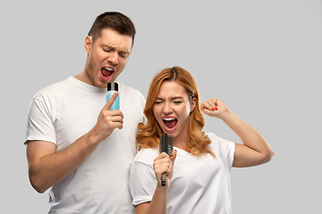 Image showing happy couple singing to hairbrush and lotion