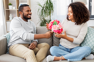 Image showing happy couple with bunch of flowers at home