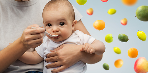 Image showing close up of mother with spoon feeding little baby