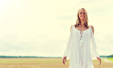 Image showing smiling young woman in white dress on cereal field