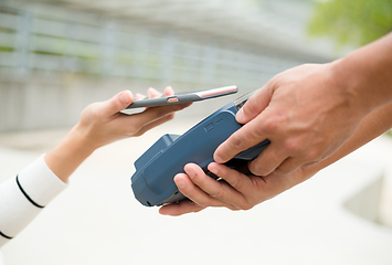 Image showing Woman pay the bill with mobile phone