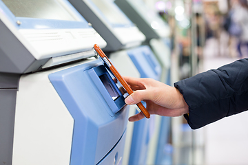 Image showing Woman using mobile phone for paying on machine