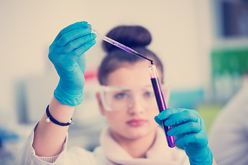 Image showing female student with protective glasses making chemistry experime