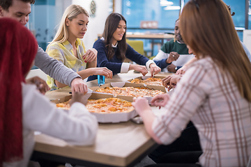 Image showing multiethnic business team eating pizza