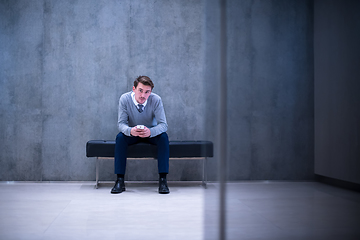 Image showing businessman using smart phone while sitting on the bench