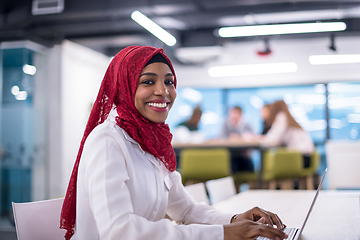 Image showing black muslim business woman ,working on laptop computer