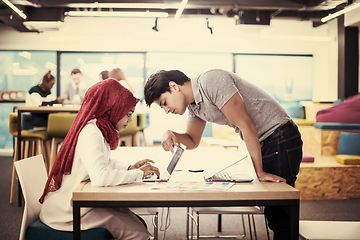 Image showing black muslim business woman having a meeting with her indian mal