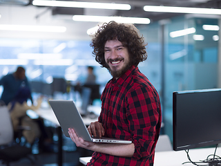 Image showing smiling male software developer using laptop