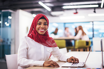 Image showing black muslim business woman ,working on laptop computer