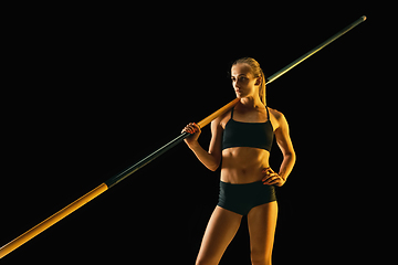 Image showing Female pole vaulter training on black studio background in neon light