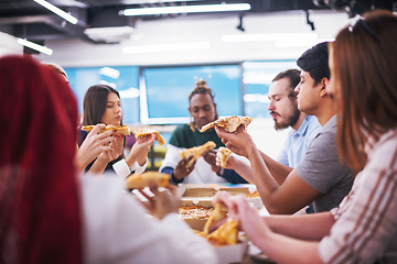 Image showing multiethnic business team eating pizza