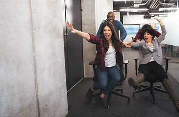 Image showing multiethnics business team racing on office chairs