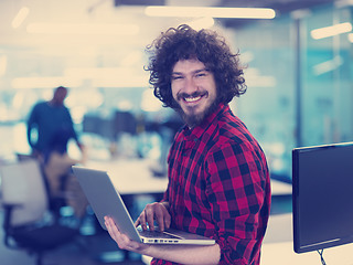 Image showing smiling male software developer using laptop