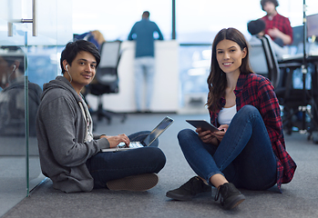 Image showing young software developers couple working on the floor