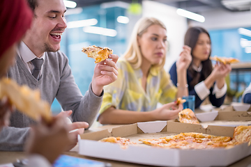 Image showing multiethnic business team eating pizza