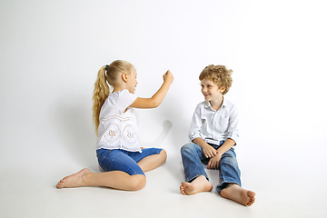 Image showing Boy and girl playing together on white studio background