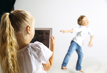 Image showing Boy and girl playing together on white studio background