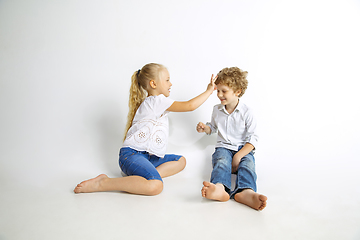 Image showing Boy and girl playing together on white studio background