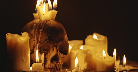 Image showing Candles and human skull in darkness closeup footage