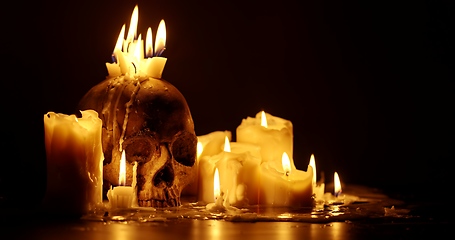 Image showing Candles and human skull in darkness closeup footage