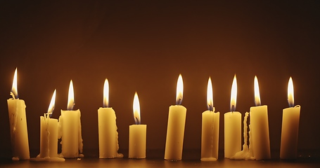 Image showing Candles glowing against dark background