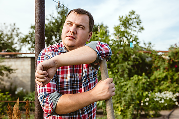 Image showing Young farmer working at his garden in sunny day