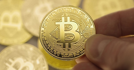 Image showing Inspecting Physical bitcoin held in hands closeup