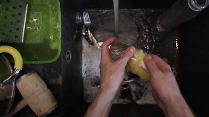 Image showing Washing dirty dishware in black sink