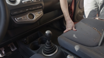 Image showing Man cleaning dirty car interior with vacuum cleaner