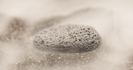 Image showing Smoke whirling around small meteorite stone