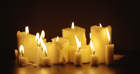 Image showing Candles glowing against dark background