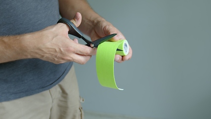 Image showing Cutting colorful tape slow motion footage