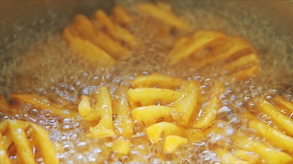 Image showing French fries boiling in sunflower oil