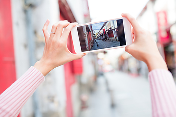 Image showing Woman taking photo on cellphone in Macau