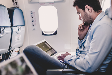 Image showing Businessman working with laptop on airplane.