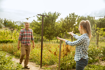 Image showing Young and happy farmer\'s couple at their garden in sunny day