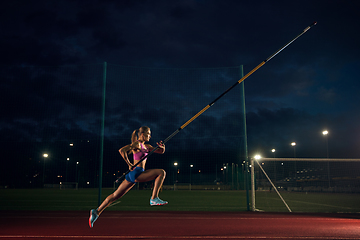 Image showing Female pole vaulter training at the stadium in the evening